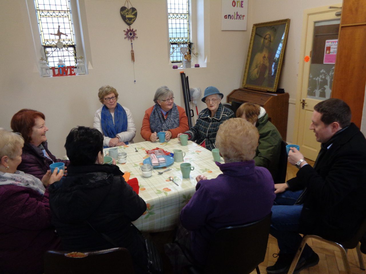 People gathered around the table in St. Teresa’s Kingdom Café, open every Thursday after the 10 am Mass.